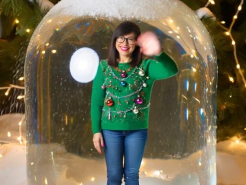 Winke gut gelaunt aus einer Schneekugel bei sanftem Schneefall